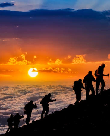 group of hikers climbing mountain during sunrise